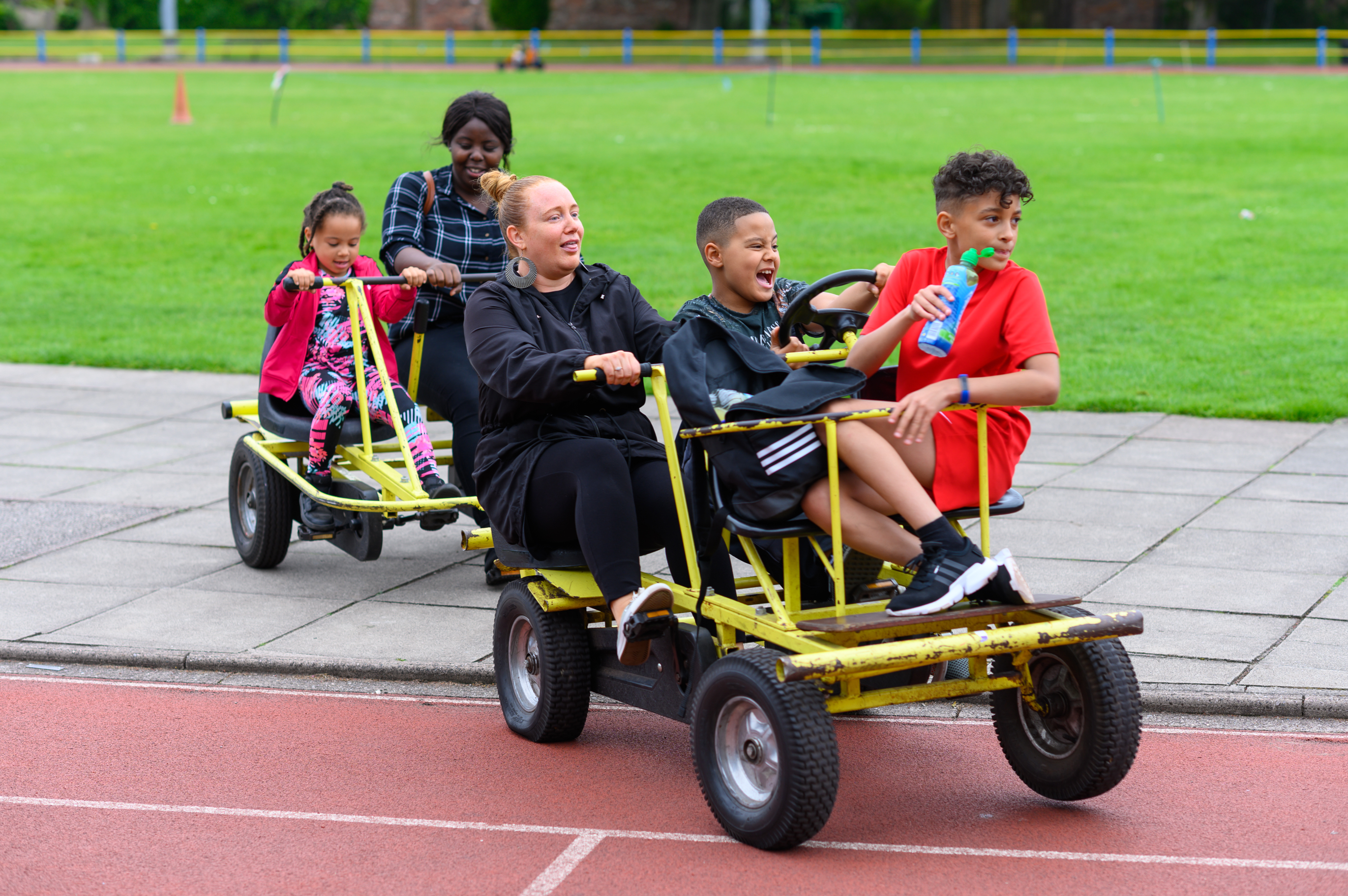 Group of children and young adults on large multiple person bicycles
