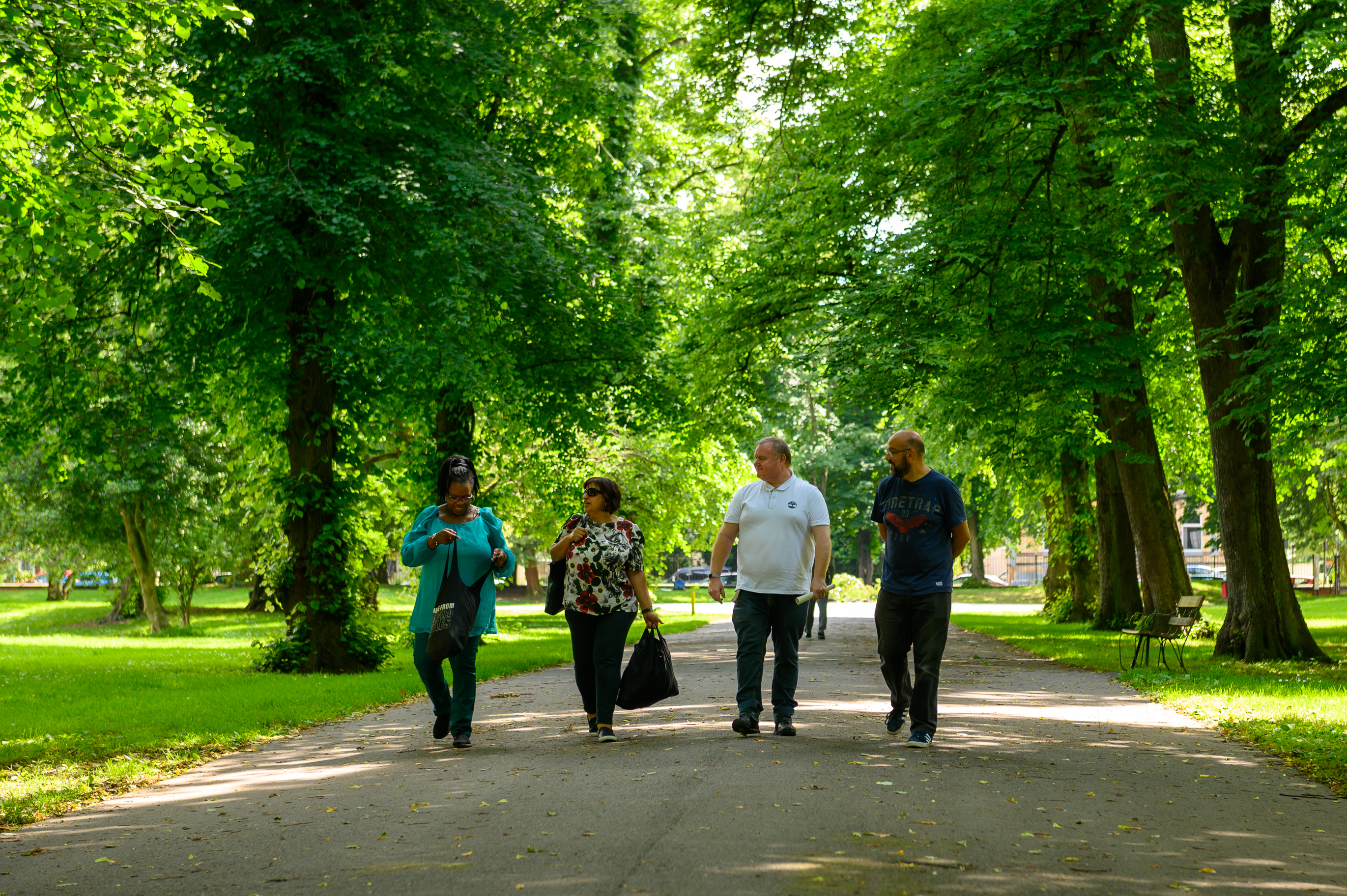 Group of four people walking through a park