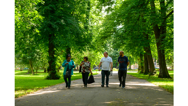 Group of four people walking through a park