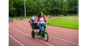 Woman on family bike with child on seat behind