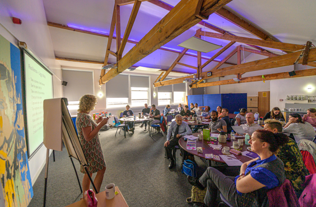 Group of people in a workshop looking at the tutor