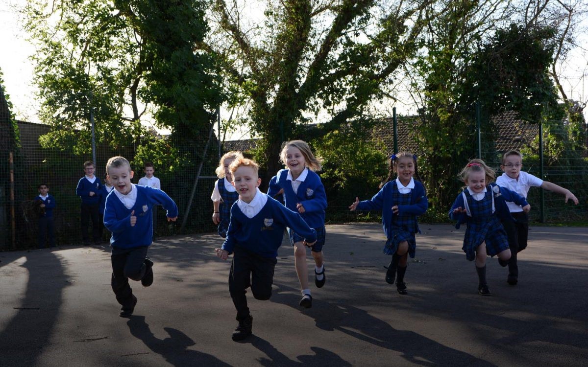 Schoolchildren running around their playground doing The Daily Mile