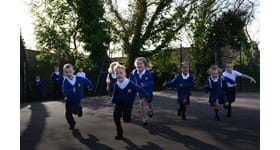 Schoolchildren running around their playground doing The Daily Mile