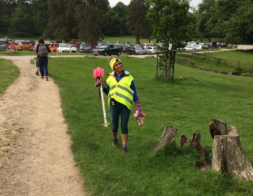 Lindsey in a park in a high visibility jacket setting up parkrun