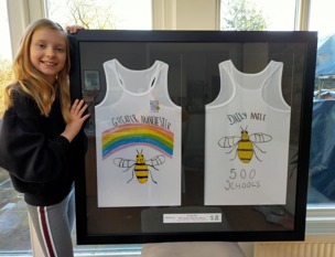 Freya stood next to her framed designed jersey