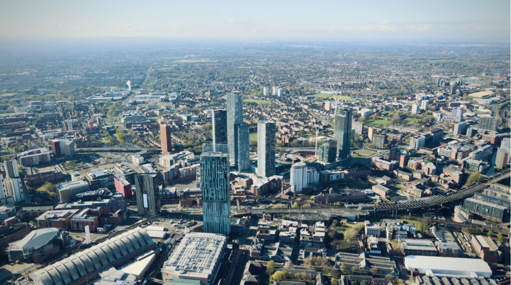 An image of Manchester city centre from the sky, showing Greater Manchester in the distance