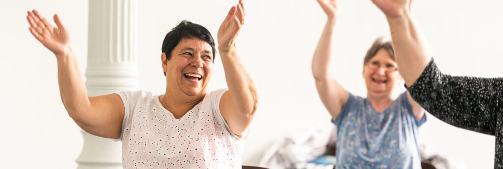 People sit and clap together in an exercise class