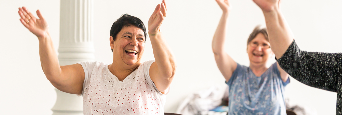 People sit and clap together in an exercise class