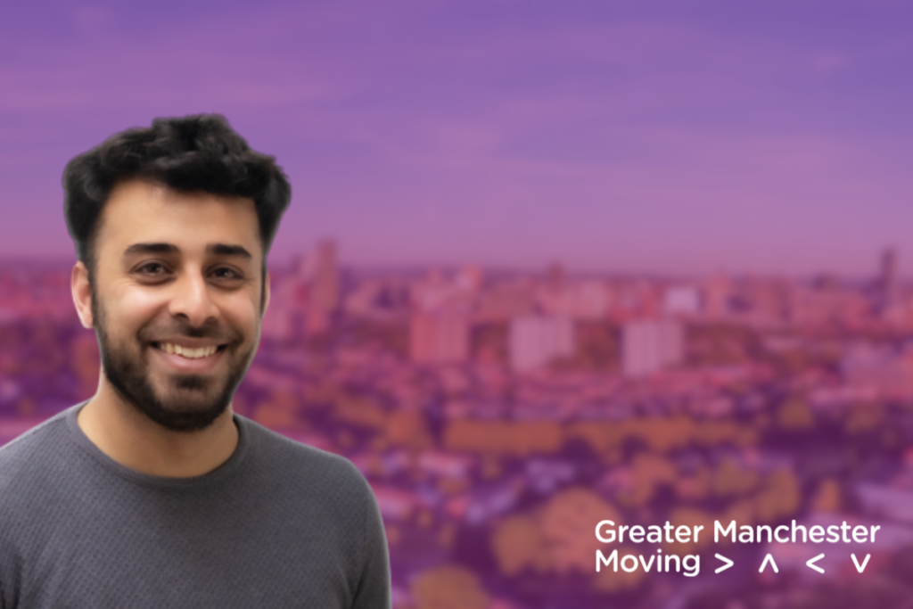 man standing in front of a background showing manchester skyline