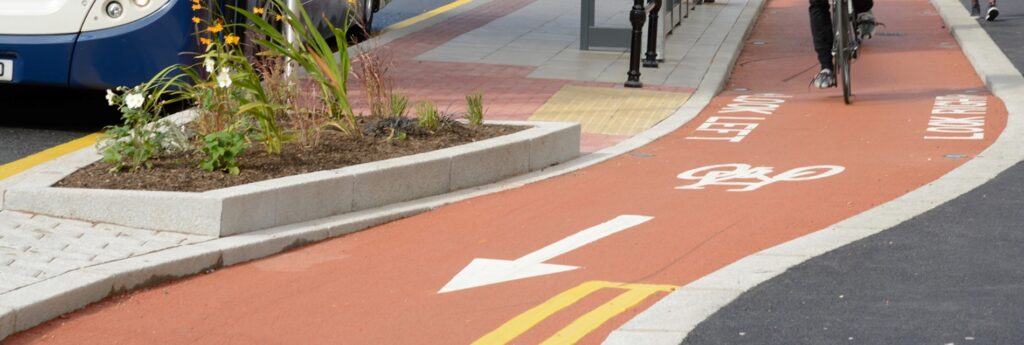 Cyclists use the Oxford Road cycle lane in Manchester, near a bus stop