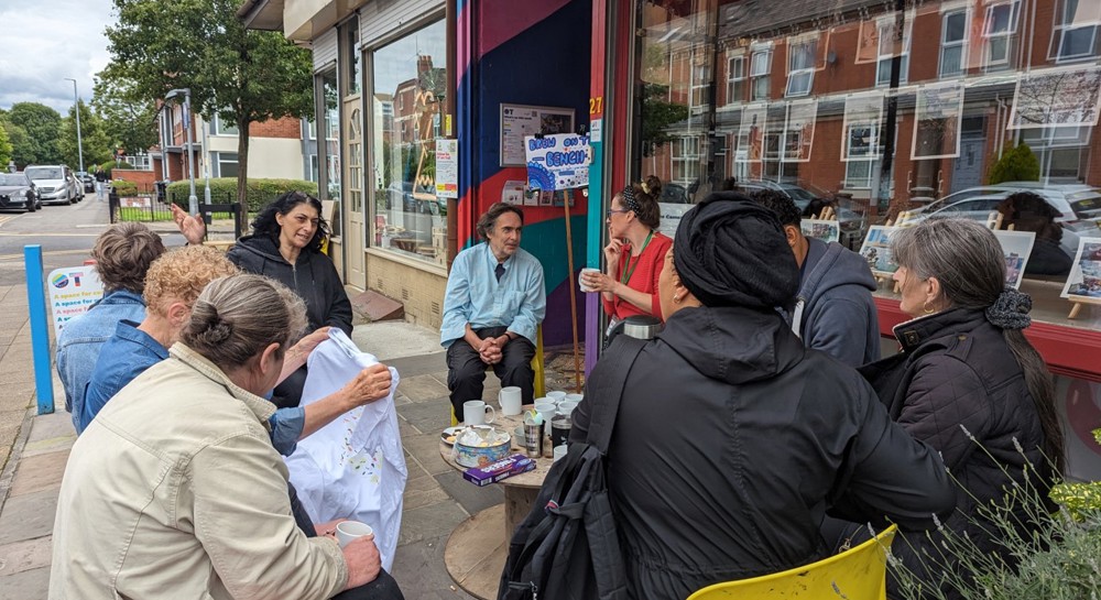A group of adults sit and talk outside a cafe