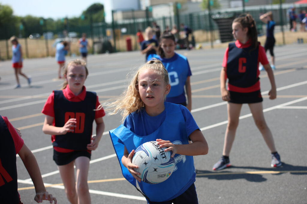 young girls in a playground playing netball