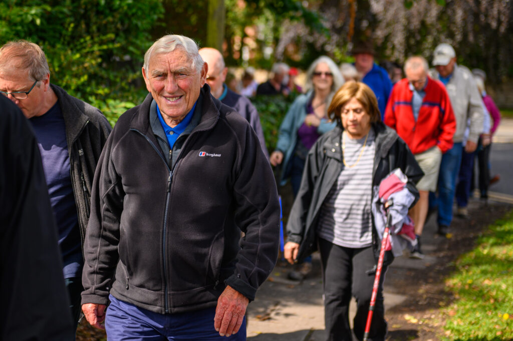 A group of adults walking on a sunny day