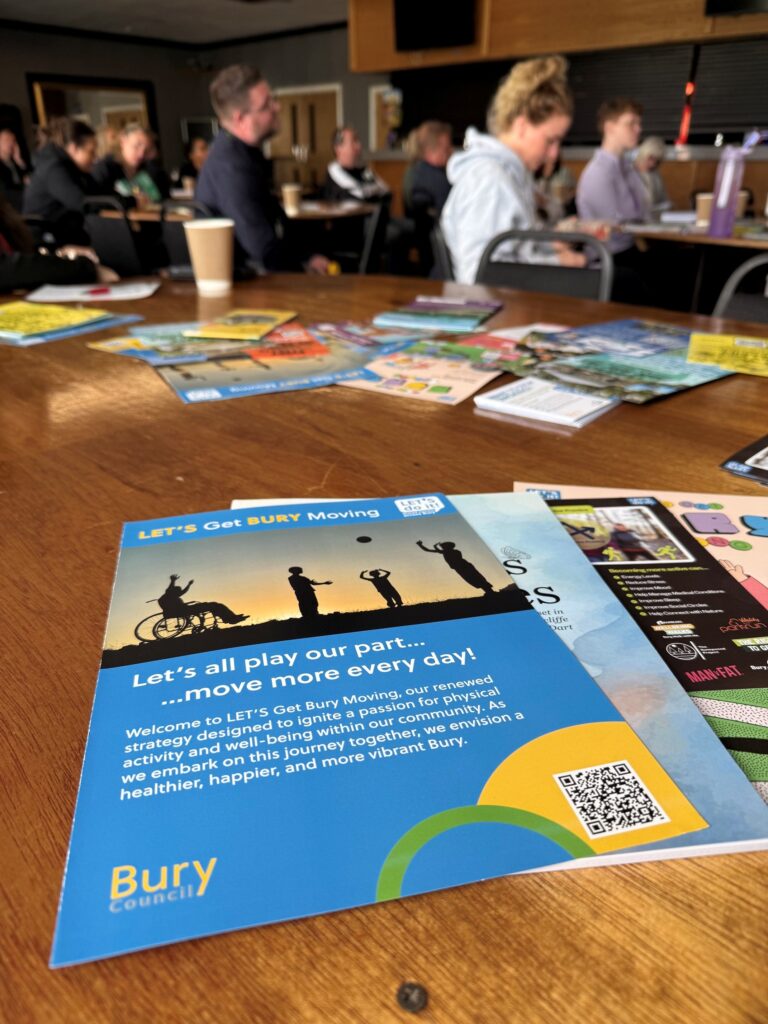 A blue Lets Get Bury Moving flyer on a table