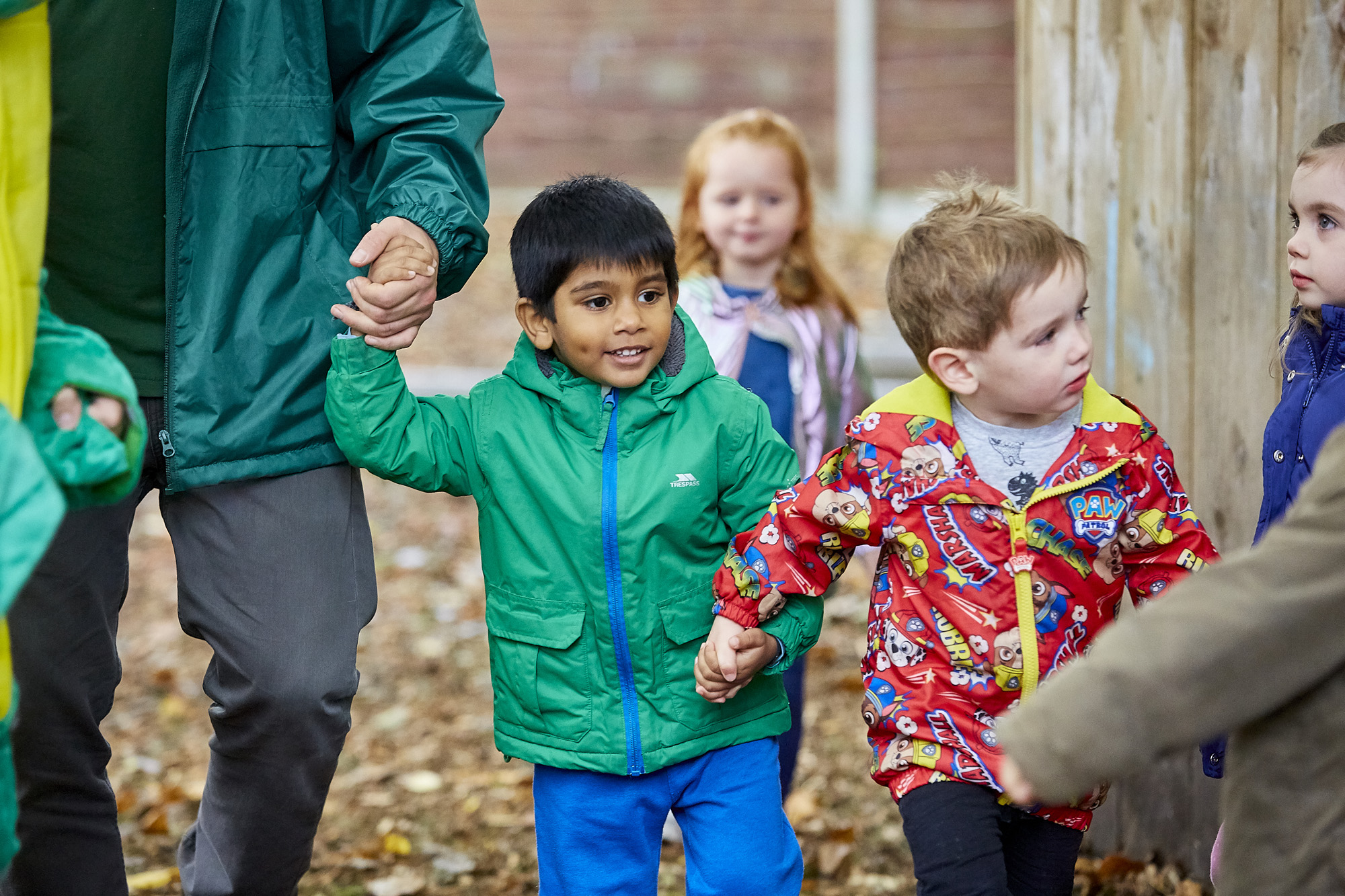 Toddler aged children heading into a play setting outdoors