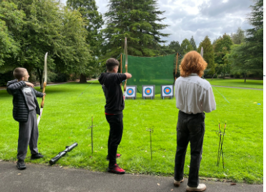 3 people aiming for the Archery target