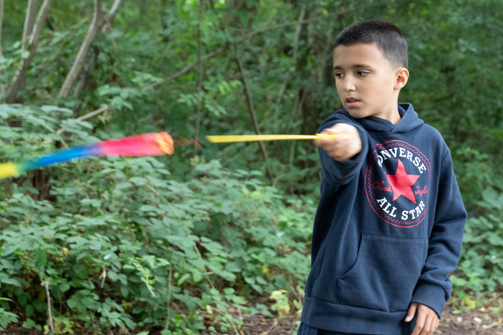 A young person swinging a bat outside