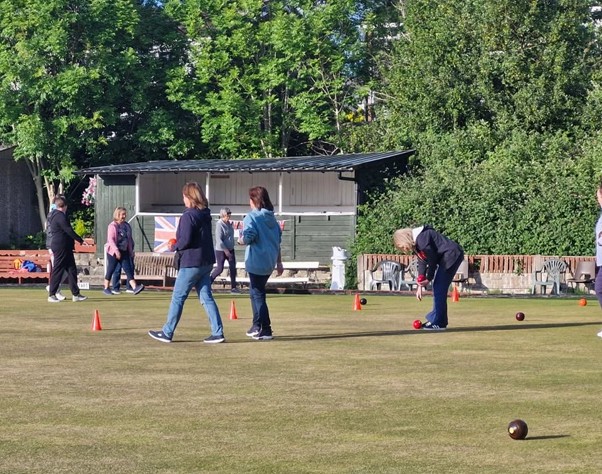 A group of adults on a bowling green